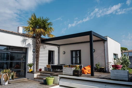 photo réaliste pergola bioclimatique de conception moderne avec des lattes d'aluminium qui se dresse près d'une maison moderne avec piscine, avec salle à manger, riche en végétation