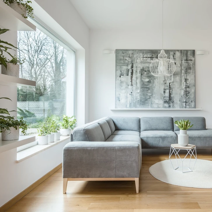 Espace de vie moderne ouvert avec cuisine intégrée et grande baie vitrée donnant sur jardin paysager