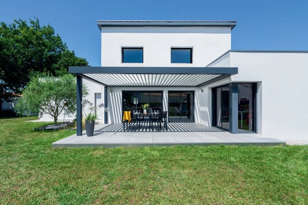 Porte de garage extérieure à trois vantaux en aluminium laqué brun chocolat, montée sur une façade en pierre